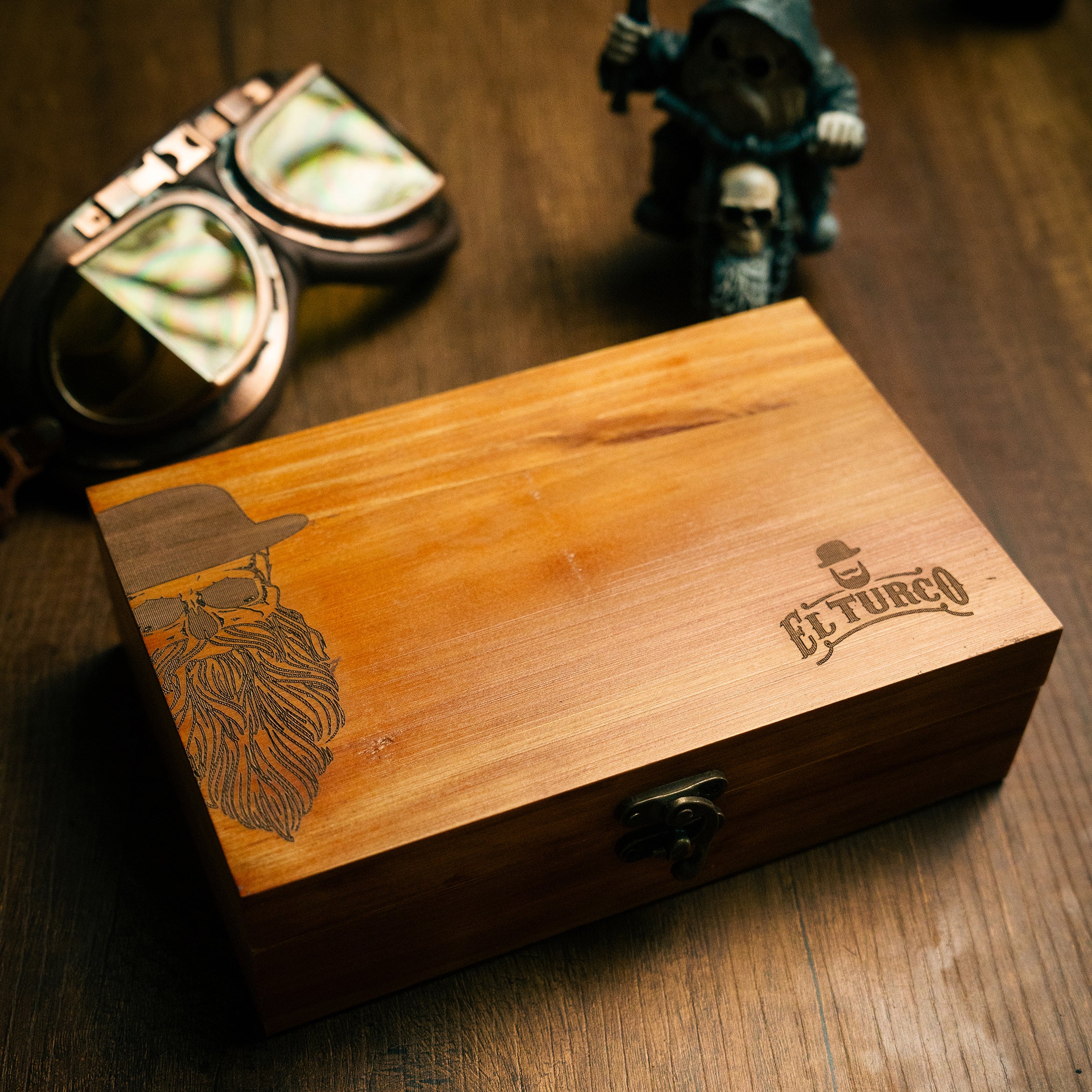 Engraved wooden El Turco box with bearded man illustration, closed, on a dark wood table