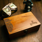 Engraved wooden El Turco box with bearded man illustration, closed, on a dark wood table